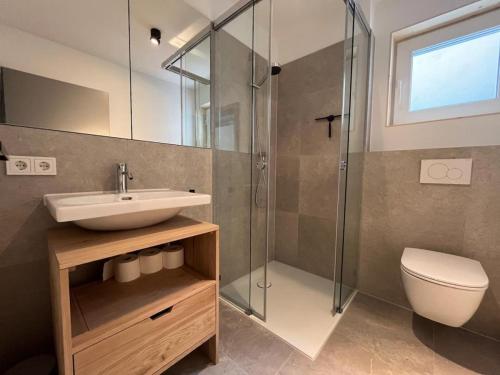 Un baño con lavabo, ducha e inodoro. en Ferienwohnung Bergufer - Studio im Souterrain, en Oberammergau