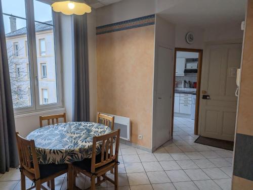 ein Esszimmer mit Tisch und Stühlen und einem Fenster in der Unterkunft Villa saint hubert in Bourbonne-les-Bains