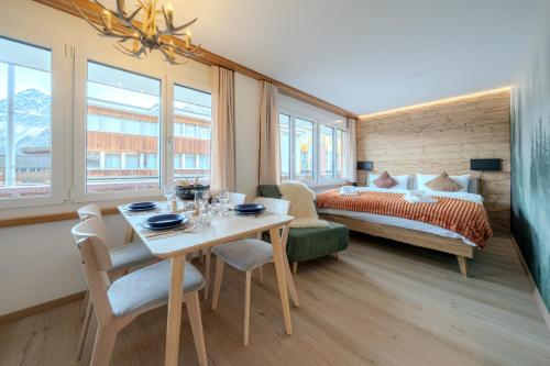 a room with a table and a bed and a bedroom at 2 Design-Studios im Zentrum by Arosa Vacations in Arosa