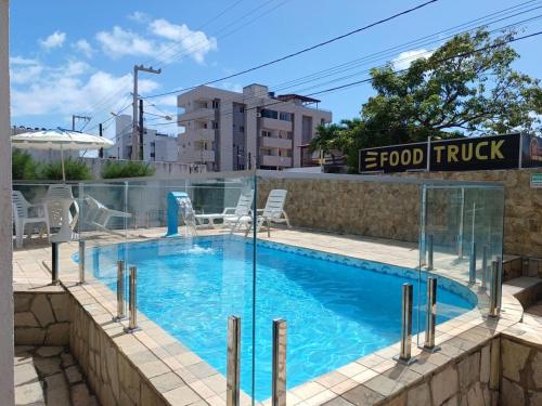 a swimming pool with a glass fence around it at Apartamentocamboinhapraiapiscinaeconforto in Cabedelo