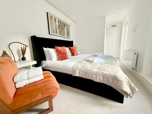 a bedroom with a large bed and a chair at Haus of Timon Victorian Elegance near Olympia in London