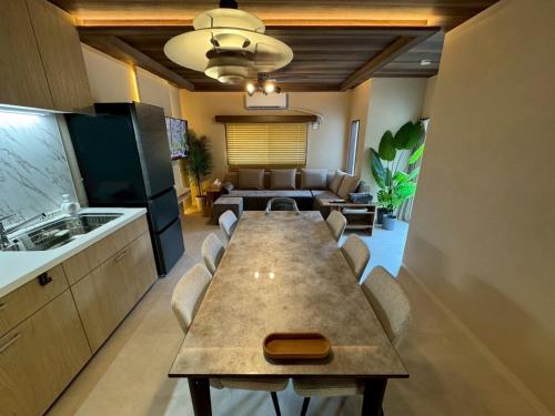a kitchen with a long table with chairs and a couch at 精神と時の宿 in Nose