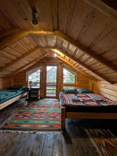 a large room with two beds and a rug at Forest House in Yasinya