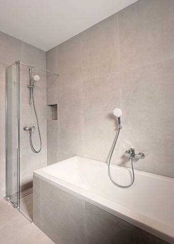 a bathroom with a bath tub and a shower at Express Apartments Suceava in Ipoteşti