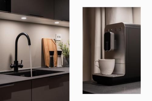 a kitchen with a sink and a microwave at Premium Penthouse in Tromsø - Northern lights, City, Sea & Mountain view in Hjorten