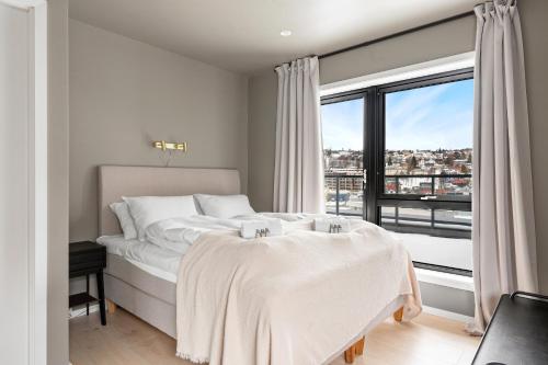 a bedroom with a bed and a large window at Premium Penthouse in Tromsø - Northern lights, City, Sea & Mountain view in Hjorten