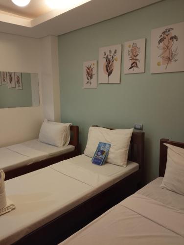 two beds in a room with drawings on the wall at Aqua Travel Lodge in El Nido