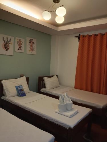 a room with two beds and a window at Aqua Travel Lodge in El Nido