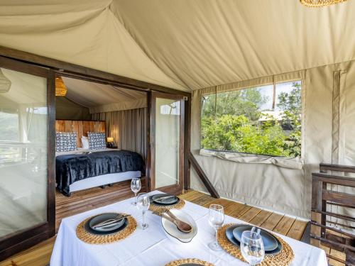 Zimmer mit einem Zelt mit einem Tisch und einem Bett in der Unterkunft Howberry Hills in Plettenberg Bay