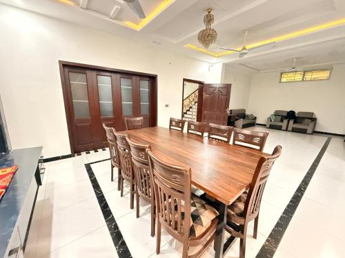 a dining room with a wooden table and chairs at Sky Lodge Guest House in Islamabad