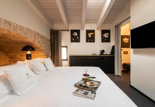 Dimora San Nicola Charming Suite في كونفيرسانو: غرفة نوم بها سرير أبيض عليه صينية طعام