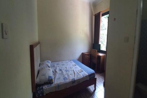 a small bedroom with a bed and a window at OYO 95054 Prima Jaya Homestay Syariah in Kedungtengkong