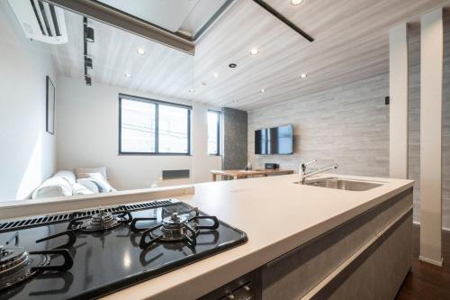 a kitchen with a stove and a sink at Restia Solace in Sapporo