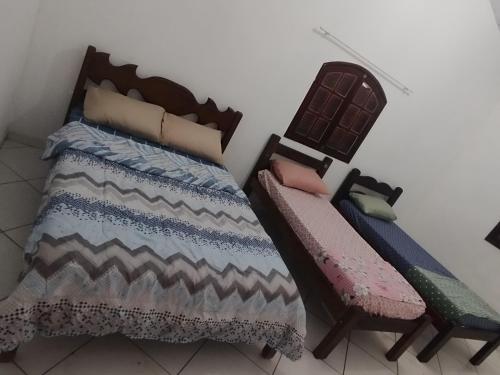 un letto e due sedie in una stanza di Paradise a Saquarema