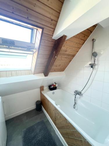 ein Bad mit einer Badewanne und einem Fenster in der Unterkunft Maison en bord de mer in Concarneau