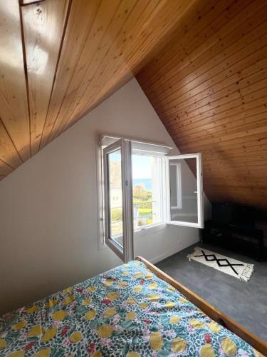 ein Schlafzimmer mit einem Bett und einem Fenster in der Unterkunft Maison en bord de mer in Concarneau