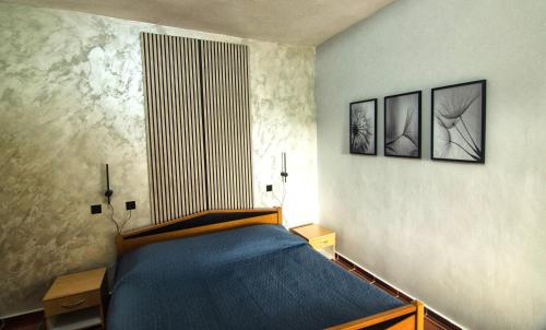 a bedroom with a bed and two pictures on the wall at Room PARADINOVIĆ in Zambratija