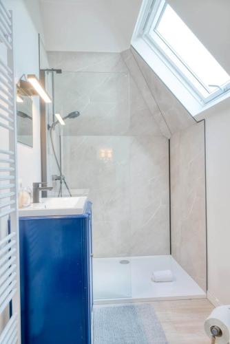 a bathroom with a shower and a sink and a window at Cozy apartment with stunning view over the fields in De Haan