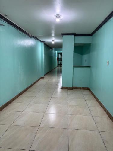Una habitación vacía con paredes azules y suelo de baldosas. en Quarto privado no centro 305, en Manaus