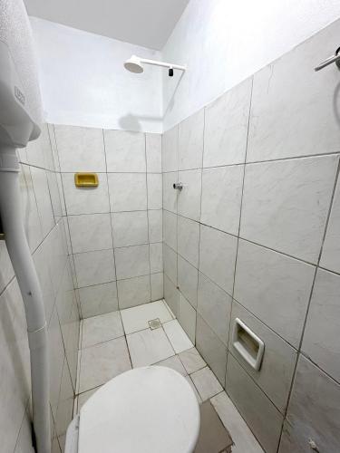 a white bathroom with a toilet and a shower at Quarto privado no centro 305 in Manaus