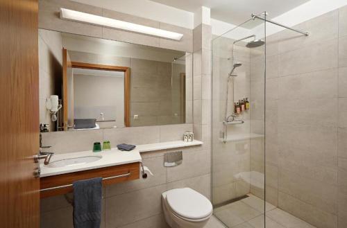 a bathroom with a toilet and a sink and a shower at Hotel Hamar in Borgarnes