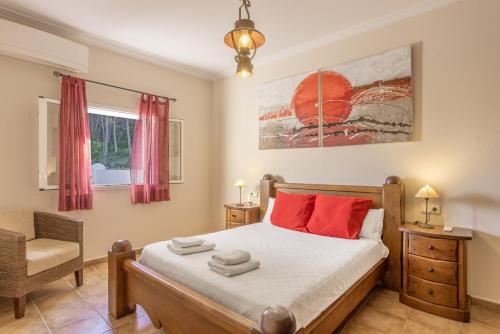 a bedroom with a bed with red pillows and a chair at Can Pepe Pujolet in Santa Gertrudis de Fruitera