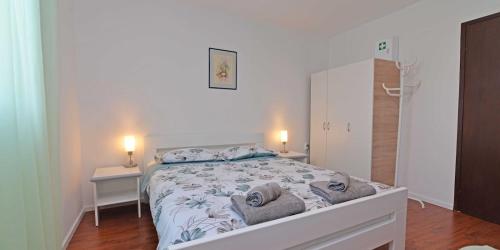 Un dormitorio con una cama con dos mesas y un espejo. en Castello, en Mali Lošinj