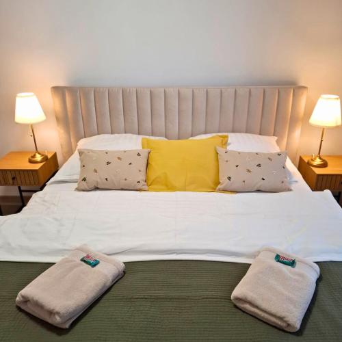 a large white bed with two towels on top of it at Apartmán 103 in Spišská Nová Ves