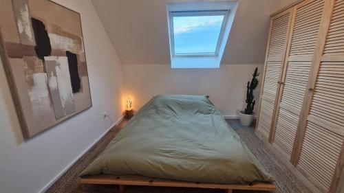 a bed in a room with a window at Logement entier appartement Bischoffsheim in Bischoffsheim