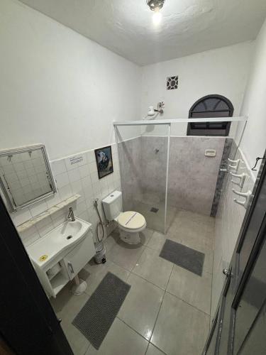 a bathroom with a toilet and a sink and a shower at Refúgio Pérola Capixaba in Marataizes