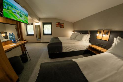 ein Hotelzimmer mit zwei Betten und einem Flachbildfernseher in der Unterkunft Villa Veranda in Smoljan