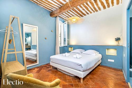 Maison de Caractère - Au cœur de Lourmarin في لورمارين: غرفة نوم بسرير وسلم ومرآة