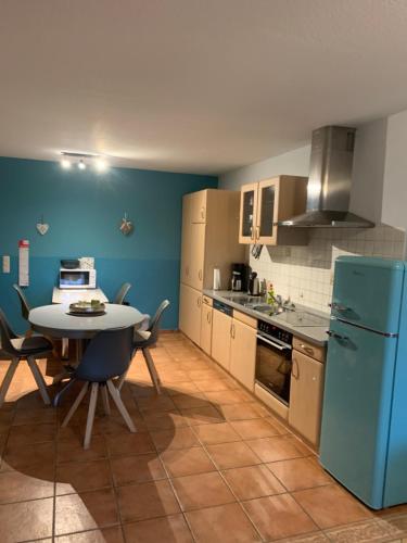 a kitchen with a table and a blue refrigerator at Ferienhaus Staben in Eggstedt