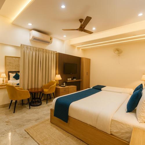 a bedroom with a bed and a desk and a television at Four Season Vrindavan # Near Prem Mandir # Luxury Rooms # Prime Location # Property Of The Year # By chandrodaya orchid # in Vrindāvan