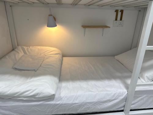 Ένα ή περισσότερα κρεβάτια σε δωμάτιο στο Putih Hostel