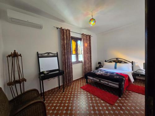 een slaapkamer met een bed en een spiegel bij Appartements Dar Rahma in Chefchaouene