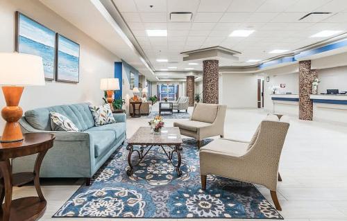 a lobby with a couch and chairs and a table at Beach Access Elegant Studio near Top Attractions in Daytona Beach