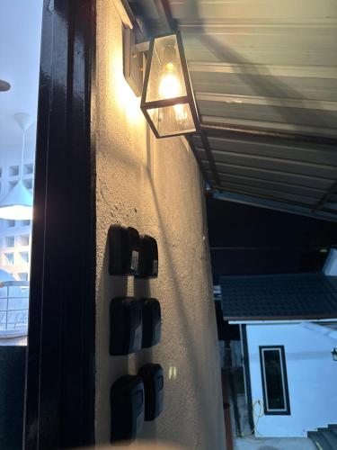 a light hanging on a wall next to a room at Putih Hostel in Klang