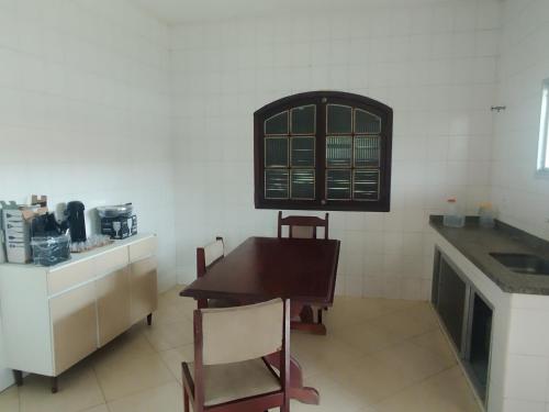 una cucina con un tavolo e sedie in legno in una stanza di Paradise a Saquarema