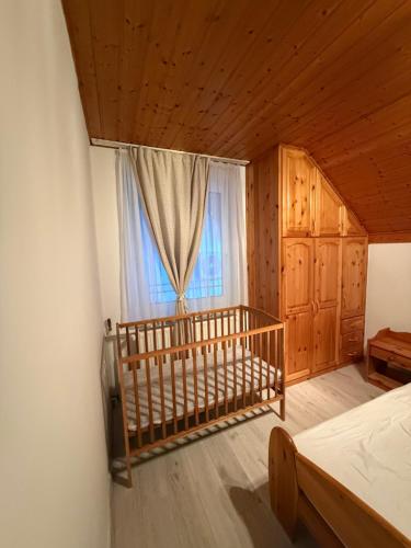 a bedroom with a bed and a window at Márta Vendégház in Gyenesdiás