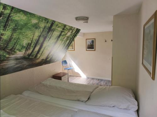 una camera da letto con un letto e un quadro sul muro di Ferienhaus Lemmerwald a Neerdar