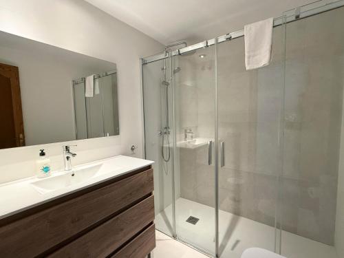 a bathroom with a glass shower and a sink at Apartamentos Colón - Grupo Antonio Perles in Calpe