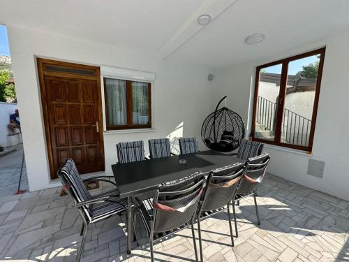 a dining room with a black table and chairs at Villa Sale Buna in Mostar