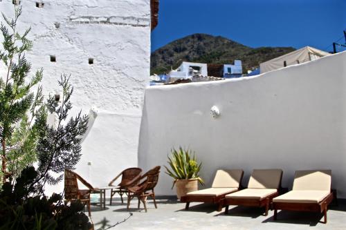 un patio con sedie e una parete bianca. di Dar Jiblia a Chefchaouen