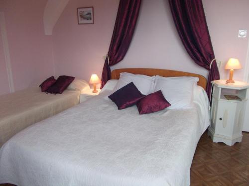 una camera da letto con due letti con cuscini rossi di Le Logis Des Grenouilles B&B a Morieux