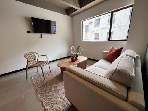 a living room with a couch and a chair at Moore 45 Tu Espacio Comodo en Medellín in Medellín