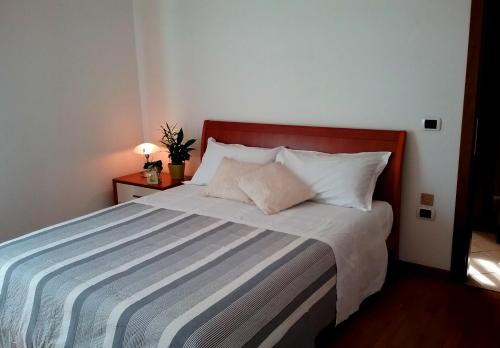 a bedroom with a large bed with a striped blanket at Appartamento ai Tigli in Noale