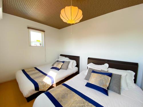 a bedroom with two beds and a chandelier at OKINAWA POOLWILLA ONNA 4A / Vacation STAY 70971 in Baba