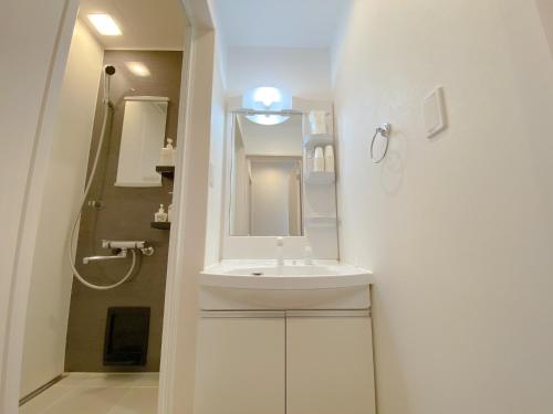 a white bathroom with a sink and a mirror at OKINAWA POOLWILLA ONNA 4A / Vacation STAY 70971 in Baba