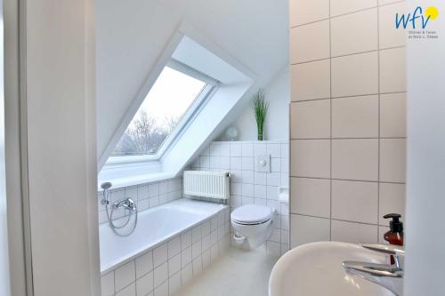 万根沃格Ferienhäuser Jadehörn Ferienhaus Dünen Hus的浴室里有马桶、洗手池和窗户。